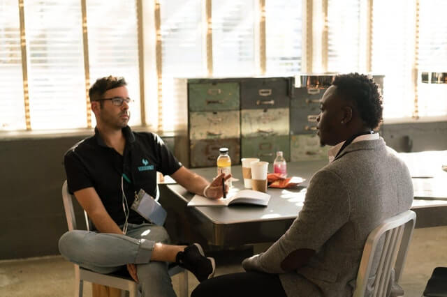 Two men discussing their recruitment in the office, along with strategy for clients, real estate, and web development. Two men discussing their recruitment in the office, along with strategy for clients, real estate, and web development.